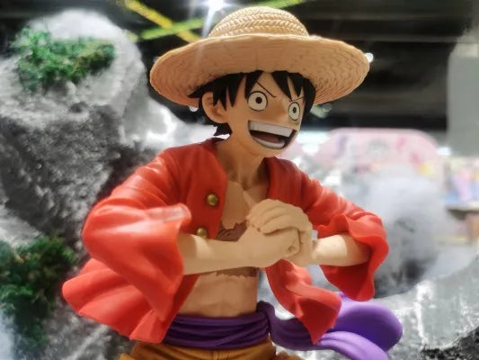 Figura Monkey D. Luffy - Colección Grandista (Banpresto Original) en exhibición con fondo de paisaje rocoso. Expresión fiel al personaje del anime.