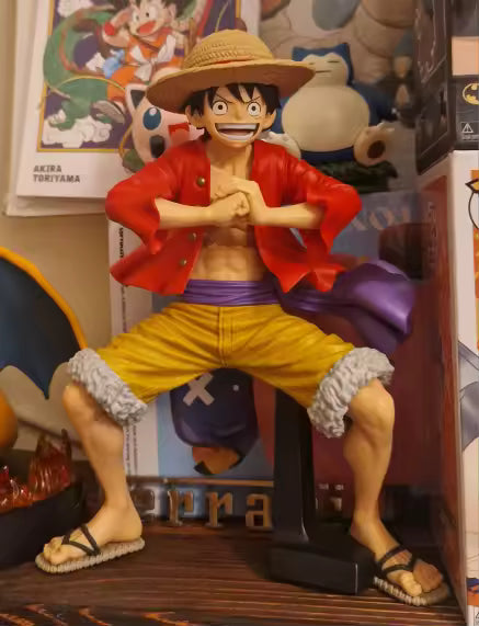 Figura Monkey D. Luffy - Colección Grandista (Banpresto Original) exhibida en estantería con fondo de otros personajes de anime. Ideal para coleccionistas.